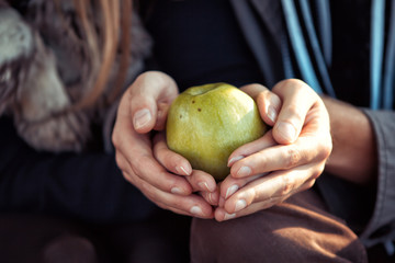 a pair of lovers holding a green apple