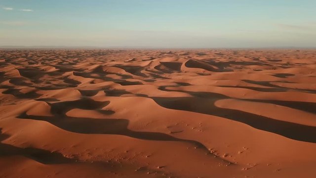 Flying over sand dunes in Sahara desert at sunrise, Africa