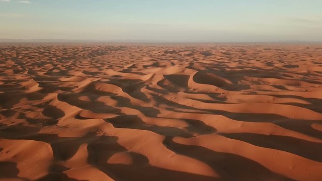 Flying over sand dunes in Sahara desert at sunrise, Africa