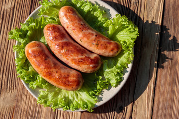 Grilled sausages on wooden table