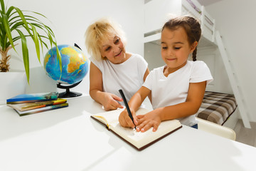 Portrait of grandmother and granddaughter doing homework