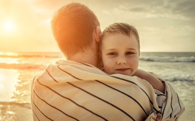 Happiness Father and son stay on the sea beach after swimming under sun
