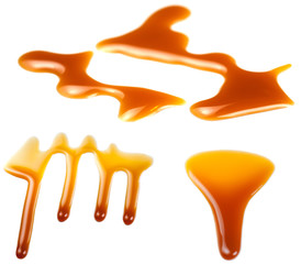 Caramel splashes isolated on white background. Spilled caramel sauce, toffee toppings