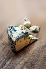 Blue cheese Gorgonzola on a rustic wooden background. Mold cheese with copyspace