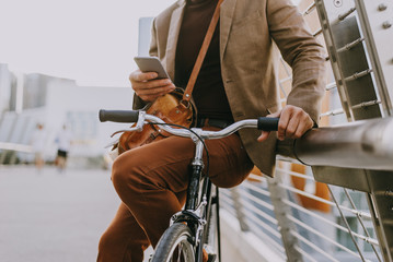 Handsome young business man with his modern bicycle.