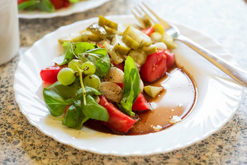 Tomato, gherkins, basil & grapes salad with vinaigrette dressing 