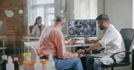 Doctor measuring pulse of the old man. An elderly man and a doctor in the office. Caring and attentive doctor checks health of an elderly patient