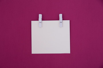 Blank of white paper note on a purple background.