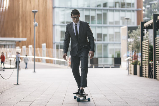 Handsome young business man with his modern longboard