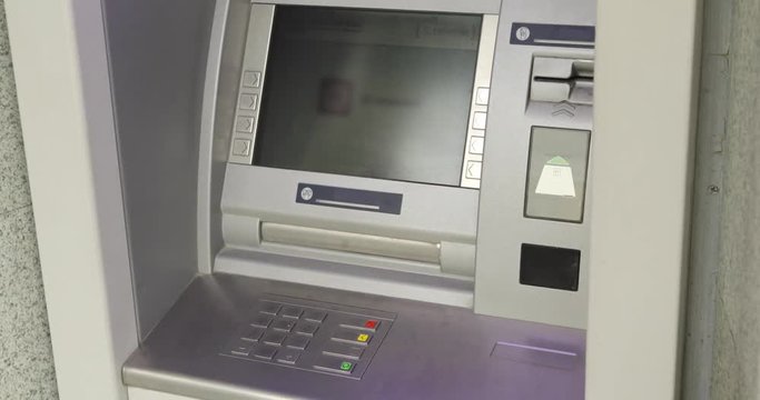 Mans hand takes a bundle of money in an ATM