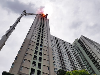Firefighter rescue training people in hight-rise building to escape by using  extended ladder crane of fire truck. Fire drills and training concept.