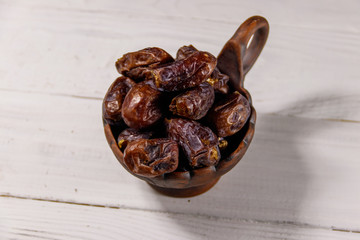 Dried dates fruit on white wooden table