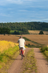 Obraz premium Man cycling on a dirt road in the country