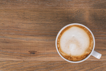 top view of fresh cappuccino on wood oak table