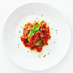 zucchini with tomato sauce decorated with basil leafs