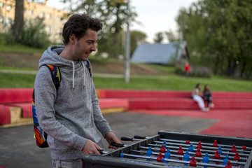 dissatisfied young man playing tablefootball in park in moscow