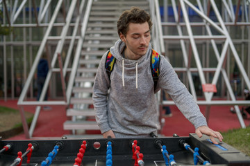 young man playing tablefootball and changing score in park in moscow