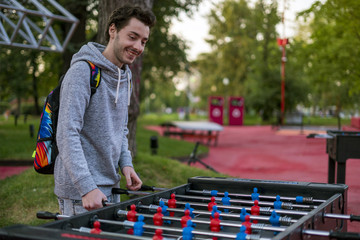 happy young man playing tablefootball in park in moscow