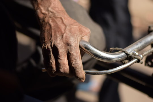 Hand Of Old Man Driving Cycle Rickshaw In Delhi India