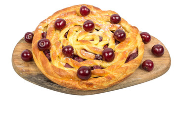 Delicious homemade cherry pie with a fresh berries on wooden cutting board isolated on white background