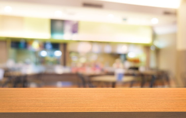 Empty dark wooden table in front of abstract blurred bokeh background of restaurant . can be used for display or montage your products.Mock up for space.