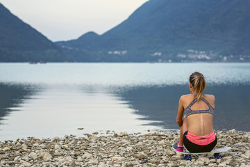 Girl sitting and looking at a lake
