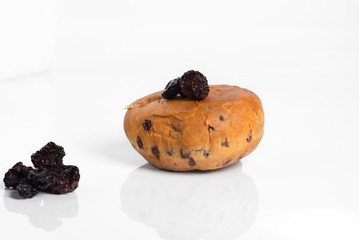 Buns with raisins on a white background with reflection.