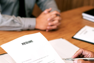 Examiner reading a resume during job interview at office Business and human resources concept