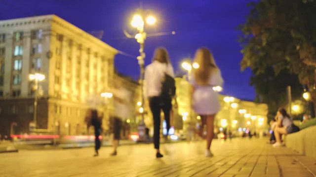 Crowds of unrecognizable people walking by night city street. Timelapse UHD 4k footage