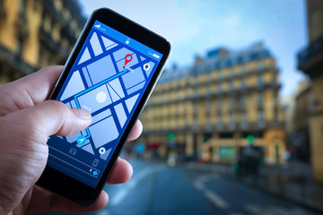 Close up of Tourist using GPS map navigation on smartphone application screen for direction to destination address in the city with travel and technology concept.