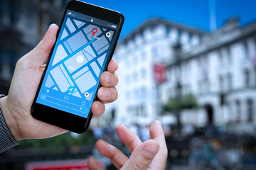 Close up of Tourist using GPS map navigation on smartphone application screen for direction to...