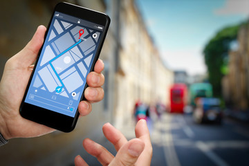 Close up of Tourist using GPS map navigation on smartphone application screen for direction to destination address in the city with travel and technology concept.