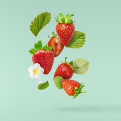 Flying Fresh tasty ripe strawberry with green leaves