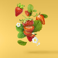 Flying Fresh tasty ripe strawberry with green leaves