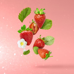 Flying Fresh tasty ripe strawberry with green leaves