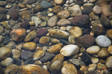 Multicolored stones on the river bed