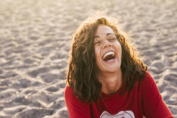 bright picture of laughing woman on the beach. backlight sunlight in nbackgroiund. beautiful young...