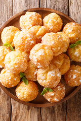 French profiteroles Chouquettes  with pearl sugar and mint closeup on a plate. Vertical top view