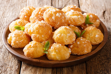 French Chouquettes with pearl sugar cooked according to a traditional recipe closeup on a plate....