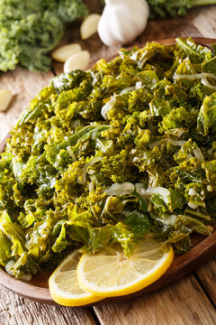 Vegetarian food: fried kale cabbage with onions and garlic close-up. vertical