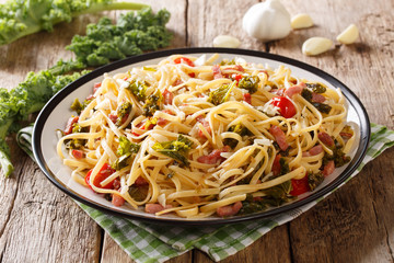 Organic food: pasta seasoned with fried bacon, parmesan cheese and vegetables close-up on the table. horizontal
