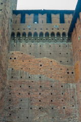 A view of a high castle wall with brown bricks