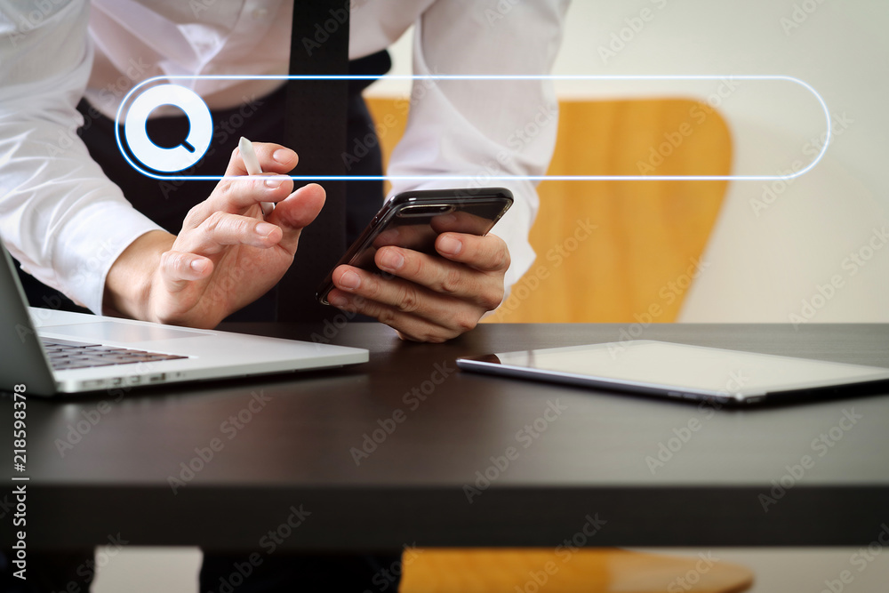 Poster close up of businessman working with smart phone and digital tablet and laptop computer on wooden de