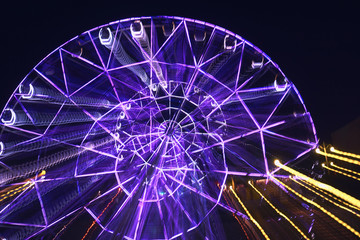 Lubricated when moving the camera on a long exposure illuminated by bright colors, the Ferris wheel in the park creates different varints of lines of light and colors for the background and patterns