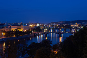 Fototapeta premium Night landscape or cityscape Picture of bridges over the Vltava river in the old historical city centre or downtown of Prague, capitol of Czech Republic, Europe. 