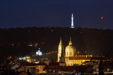 Fototapeta na wymiar Night landscape or cityscape Picture on historical center of the Prague, quarter named Mala strana with Saint Nicolas church and Petrin tower on the hill over the city.