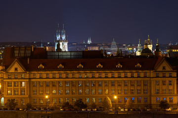 Fototapeta na wymiar Night landscape, city scape picture of old town in Prague from bank of Vltava, Moldau river to Old square with towers of Tynsky temple, combination historic architecture