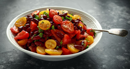 Healthy Red beans and mix of organic red and yellow cherry tomatoes salad topped with parsley.