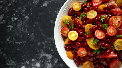 Healthy Red beans and mix of organic red and yellow cherry tomatoes salad topped with parsley.