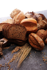 Sliced rye bread on cutting board. Whole grain rye bread and rolls with seeds.